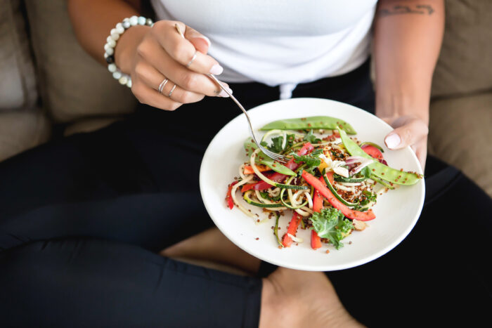 plate with healthy vegetable stirfry with woman holding it